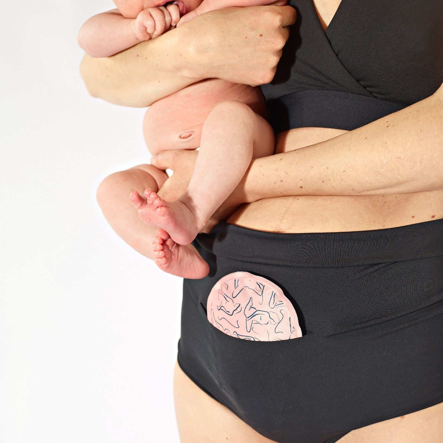 Image of woman in FourthWear Postpartum Recovery Underwear holding baby